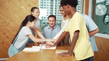 Kafkas öğretmeni ve çeşitli çocuklar başarılı bir projeyi kutlamak ya da sınıfta teşvik etmek için el ele tutuşuyorlar. Aşkı, şirketi, takım çalışmasını, birlikteliği ve birliği temsil et. Öğretim