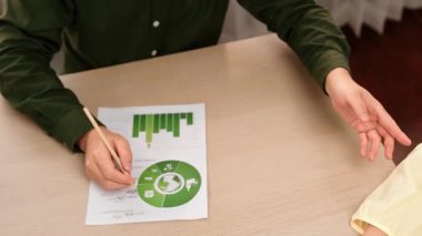 Mükemmel iş adamları, karbon ayak izini azaltmak, Dünya 'yı kurtarmak için grafik, yel değirmeni, ev ve ağaç modelini kullanarak yeşil enerjili eko ev projesinde işbirliği yaparlar. Eline odaklan. Tanımlama.