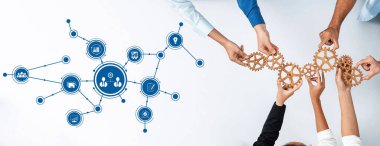 Çeşitli bir grup el, dişlileri ve ağ sembollerini birbirine bağlayarak birlikte çalışır. Bu görüntü, iş ortamlarındaki işbirliğinin ve yenilikçi stratejilerin gücünü gösteriyor. Dostluk