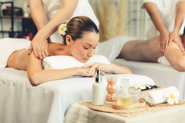 Kafkas çift müşterisi stres önleyici spa masajının keyfini çıkarıyor ve lüks otel veya oteldeki gündüz açık hava ortamında güzellik teniyle eğleniyor. Sessiz.