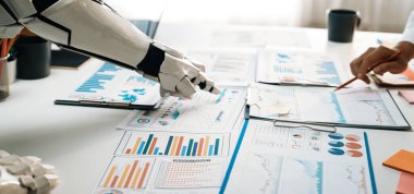 Modern bir ofiste iş analitik belgelerinde işbirliği yapan bir robot kol, teknoloji ve veri analizinin profesyonel ortamlarda entegrasyonunu gösteriyor. Noogenesis