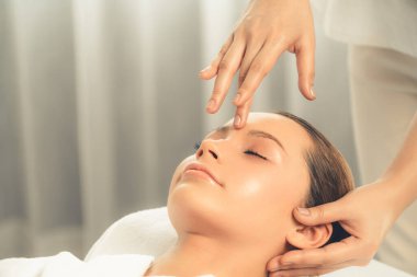 Kafkasyalı kadın stres önleyici kafa masajından ve lüks tatil beldesi ya da otel spa salonundaki modern ışık ortamında yüz güzelliği eğlencelerini şımartmaktan hoşlanıyor. Sessiz.