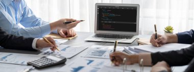 İş zekası ve veri analizi kavramı. Analizci ekibi laptop ekranında finansal veri analizi üzerinde çalışıyor. Etkili iş stratejik planlama için pazarlama göstergesi olarak. İçgörü