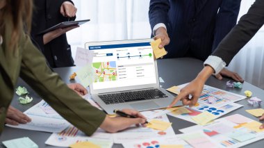 Analizci ekibi yaratıcı ve analitik beyin fırtınası fikri için bilgisayar ekranında BI veri paneli olan yapışkan bir not kullanıyor. Pazarlama stratejisi için finansal veri görselleştirme teknolojisini analiz et. Dahi.