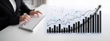 Bir iş adamı, önemli büyüme gösteren grafikleri analiz ederken, modern ve profesyonel bir çalışma alanını gösteren bir bilgisayarda finansal verilerle ilgilenir. Etki