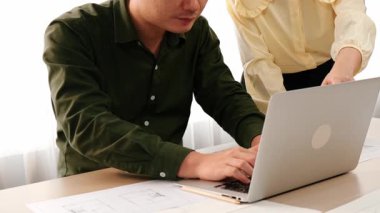 Masada dizüstü bilgisayarda ayrıntılı tasarım görüntüsünü izleyen mimar ve güvenlik mühendisi, diğer bir tasarımcı yazım planı modern ofiste doğruluk için ölçüm aracı kullanıyor. - Yakın çekim. Tanımlama.
