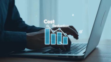 Bir iş adamı, modern bir çalışma alanında maliyet azaltma stratejilerini ve finansal büyüme anlayışlarını temsil eden dijital grafikler ve simgelerle etkileşime geçmek için dizüstü bilgisayar kullanır. Dörtgen