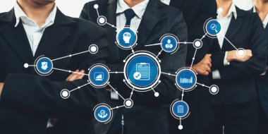 Bir grup iş adamı, takım çalışması, veri yönetimi ve kurumsal stratejiyi temsil eden ve modern işyeri işbirliğini vurgulayan dijital simgelerle çevrelenmiş bir şekilde güven içinde duruyorlar. Dostluk