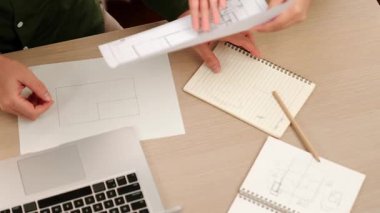 Akıllı mimar ve akıllı mühendisin dizüstü bilgisayarlı videosu mimarlık bürosundaki inşaat isabet planı hakkında tartışıyorlar. Eline odaklan. - Yakın çekim. Tanımlama.