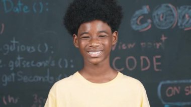 Makineye gülümseyen Afrikalı bir yetişkin. Mühendislik koduyla ya da dakik bir şekilde tahtada dururken. BTMM Teknoloji dersine katılırken günlük kıyafet giyen yakışıklı bir genç. Öğretim