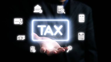 Profesyonel bir elde, modern vergi yönetimi ve istişare yaklaşımlarını vurgulayarak çeşitli mali hizmetleri temsil eden dijital simgelerle çevrili parlak bir vergi sembolü sergileniyor. Dörtgen