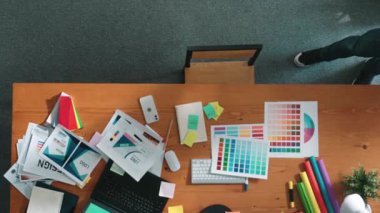 Kulaklıktan müzik dinlerken yetenekli iç dizayn grafiklerinin yukarıdan aşağı havadan görüntüsü. Proje yöneticisi kulaklıkla çalışırken ve rahat şarkılar dinlerken stüdyoda hareket ediyor. Sempozyum.