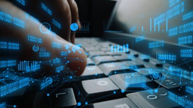 Modern teknoloji ve veri analiz temalarını vurgulayan dijital veri elemanlarıyla kaplı bir dizüstü bilgisayarın klavyesindeki tuşlara yakın çekim görüntüsü. Xenic