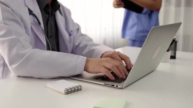 Hastane masasında birlikte çalışan ve tıbbi tedavi planlayan çeşitli profesyonel sağlık görevlileri. Takım çalışması başarılı hastalıklara ve hastalıklara yol açar. Ağır çekim. Katı.