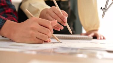 Mimarlar veya akıllı mühendislerin videosu mimari ofisindeki inşaat doğruluğu için taslak üzerinde ölçüm aracı, bölücü ve kalem el yazısı detaylarını kullanır. Eline odaklan. - Yakın çekim. Tanımlama.