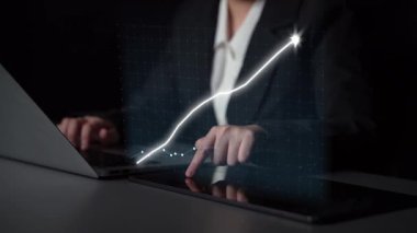 İş dünyasından bir profesyonel finansal eğilimleri analiz ederken bir dizüstü bilgisayara bağlanıyor ve günümüzde dijital çalışma alanındaki büyümeyi gösteren yükselen grafiği gösteriyor. Copula