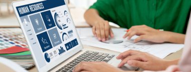 İnsan kaynakları yönetim yazılımı bilgisayar ekranında insan kaynakları çalışanlarının işe alım, maaş bordrosu, personel araması ve KPI değerlendirme çalışmalarını yönetmesine yardımcı oluyor