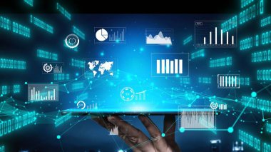 Bir kişi, modern analitik ve teknoloji eğilimlerini simgeleyen veri görselleştirmeleri, grafikleri ve ağ elemanlarıyla dolu hayret verici bir dijital arayüzü gösteren bir tablet tutuyor. Xenic