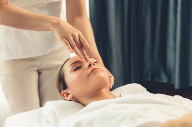 Kafkasyalı kadın stres önleyici kafa masajından ve lüks tatil beldesi ya da otel spa salonundaki modern ışık ortamında yüz güzelliği eğlencelerini şımartmaktan hoşlanıyor. Sessiz.