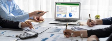 İş zekası ve veri analizi kavramı. Analizci ekibi laptop ekranında finansal veri analizi üzerinde çalışıyor. Etkili iş stratejik planlama için pazarlama göstergesi olarak. İçgörü