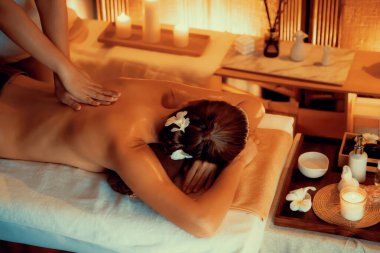 Beyaz kadın müşteri stres önleyici spa masajının keyfini çıkarıyor ve lüks otel ya da otelde sıcak mum ışığında güzellik teniyle eğleniyor. Sessiz.