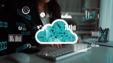 Bir iş adamı bilgisayar klavyesi ile etkileşime girerken, bir bulut teknolojisi arayüzü çağdaş ofis ortamında çeşitli veri analizleri ve grafikleri görüntüler. Xenic