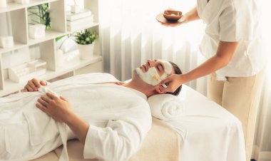 Kaplıca salonunun sakin atmosferi, insan müşterisi modern gün ışığında lüks yüz kremi masajıyla kendini yenileme zevkine kapılıyor. Yüz bakımı ve güzellik konsepti. Sessiz.