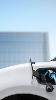 Modern ve fütüristik bina arka planında akıllı EV şarj istasyonundan elektrikli araba şarj oluyor. Alternatif ve sürdürülebilir enerji kullanan şarj edilebilir EV arabaların teknolojik gelişimi. İnceleyin