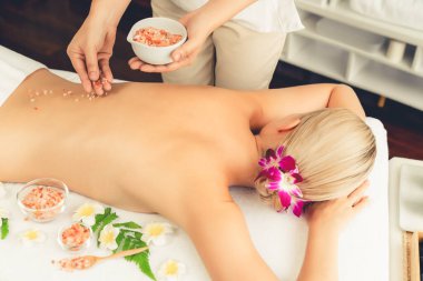 Lüks spa salonlarında sıcak mum ışığında cilt bakımı yaptıran kadın müşteri. Sağlık Spa vücut fırçasında tuz temizleme güzellik tedavisi. Sessiz.