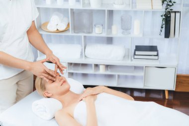 Kafkasyalı kadın stres önleyici kafa masajından ve lüks tatil beldesi ya da otel spa salonundaki modern ışık ortamında yüz güzelliği eğlencelerini şımartmaktan hoşlanıyor. Sessiz.