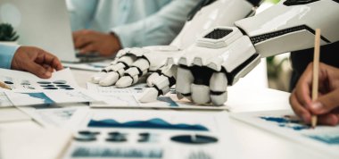 Gelecekçi bir robot el, çeşitli çizelgeler ve raporlar yoluyla veri analizine yardımcı olarak bir ofis ortamında profesyonellerle işbirliği yapar, yenilik ve takım çalışmasını vurgular.