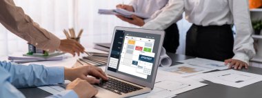 İç mimar tasarımcı grubu, daha kesin tasarım için planlar ve dizüstü bilgisayar ekran mimari yazılımı üzerinde birlikte tartışıyorlar. Modern ev tasarımı ve yenileme. İçgörü