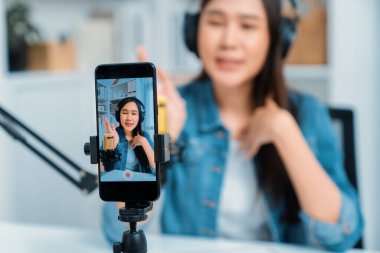 Yaratıcı yayıncı genç ve güzel Asyalı 'nın sunucu kanalındaki seçici odaklı telefon stüdyodaki dinleyiciyle günlük hayatta pazarlamayı veya danışmanı desteklemek için online olarak konuşuyor. Taktik.