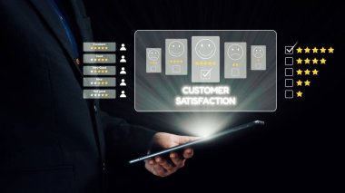 Bir işadamı, müşteri memnuniyeti ölçümlerini bir tablette inceleyerek, yıldız reytinglerini ve geri bildirim simgelerini vurgulayarak, müşteri sezgilerinin iş dünyasındaki önemini gözler önüne seriyor. Dörtgen