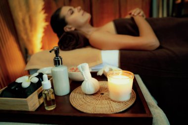Aromaterapi masajı ambiyansı ya da spa salonu kompozisyon düzeneği bulanık kadınlara odaklı dekor mumları ve spa aksesuarları ile tatil köyü veya otel arka planında keyifli aroma spa masajı yapan. Sessiz.