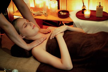 Beyaz kadın müşteri stres önleyici spa masajının keyfini çıkarıyor ve lüks otel ya da otelde sıcak mum ışığında güzellik teniyle eğleniyor. Sessiz.