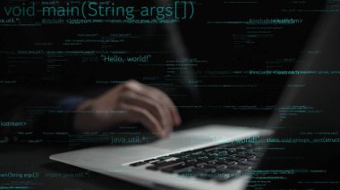 Dizüstü bilgisayarda yazı yazan bir el resmi, kod satırlarıyla çevrili. Bu görüntü, dijital çalışma alanı ortamındaki teknoloji ve programlamanın dinamiklerini vurgular. Xenic