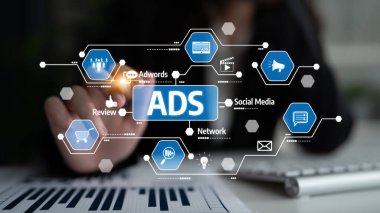 Modern ve ilgi çekici bir görüntü, dijital reklamcılığın özünü, gösterişli bir çalışma alanı ortamında belirlenmiş çeşitli ikonlar ve kavramlarla yakalıyor. Tessel