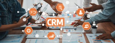 Bu resim, gelişmiş yönetim ve müşteri sezgileri için CRM stratejilerini tartışırken ellerinizi grafik ve cihazların üzerine koyarak işbirlikçi bir iş ortamı yakalar. Dostluk