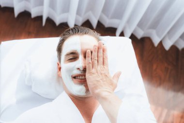 Kaplıca salonunun sakin atmosferi, insan müşterisi modern gün ışığında lüks yüz kremi masajıyla kendini yenileme zevkine kapılıyor. Yüz bakımı ve güzellik konsepti. Sessiz.