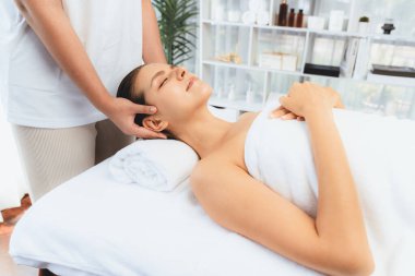 Kafkasyalı kadın stres önleyici kafa masajından ve lüks tatil beldesi ya da otel spa salonundaki modern ışık ortamında yüz güzelliği eğlencelerini şımartmaktan hoşlanıyor. Sessiz.