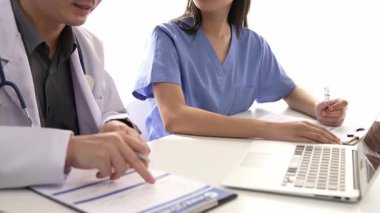 Hastane masasında birlikte çalışan ve tıbbi tedavi planlayan çeşitli profesyonel sağlık görevlileri. Takım çalışması başarılı hastalıklara ve hastalıklara yol açar. Ağır çekim. Katı.