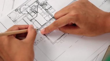 Ölçüm aracı ve kalem el kullanan akıllı mimar veya akıllı mühendisin videosu mimari ofisteki inşaat hatasızlığı için ayrıntılı bir tasarım hazırladı. Eline odaklan. - Yakın çekim. Tanımlama.