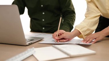 Mimar ve mühendis, modern ofisteki tablo üzerinde tasarım, ölçüm aracı ve plan için dizüstü bilgisayardaki taslak ayrıntılı taslak ile el yazısını karşılaştırıyor. - Yakın çekim. Tanımlama.