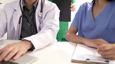 Hastane masasında birlikte çalışan ve tıbbi tedavi planlayan çeşitli profesyonel sağlık görevlileri. Takım çalışması başarılı hastalıklara ve hastalıklara yol açar. Ağır çekim. Katı.