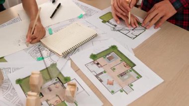 Akıllı mimar ya da akıllı mühendisin ölçüm aracı ve kalem el kullanarak mimari ofisindeki inşaat isabet planı üzerine detaylı bir yazı yazışının videosu. Eline odaklan. - Yakın çekim. Tanımlama.