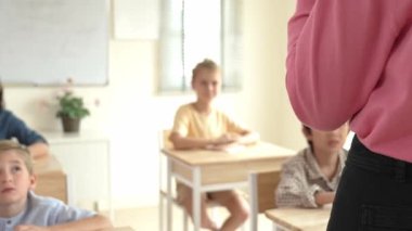 Kafkasya öğretmeninin arka görünüşü farklı öğrencilere karatahta başında durmayı öğretiyor. Profesyonel eğitmen, öğrenciyken sınıf çalışmalarını açıkla ve dikkatlice dinle. Eğitim konsepti. Pedagoji.