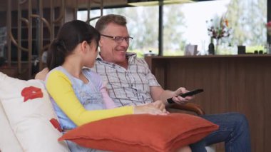 Büyükbaba ve torun birlikte TV 'de ilginç bir eğlence medyası izliyorlar. Eski üst düzey kullanım teknolojisi, genç nesil çapraz nesil ile iletişim kurarak aile bağlarını güçlendiriyor. Uyumsuzluk.