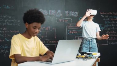 Kulaklık ya da video cihazı takan ve Afrika akademik öğrenci programlamasını, kodlama sistemini BTMM teknoloji sınıfında dünyayı canlandırmaya teşvik etmek için başparmak gösteren zeki bir kız. Yenilikçi. Öğretim