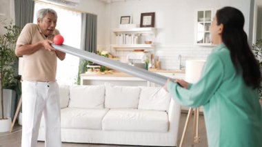 Yaşlı bir adam evde partneriyle top yuvarlama oyunu oynuyor, zihinsel ve fiziksel sağIık için el-göz koordinasyonu, odaklanma ve motor becerileri pratiği yapıyor. Sağlık hizmetleri konseptini engelliyor. Myrmidon.